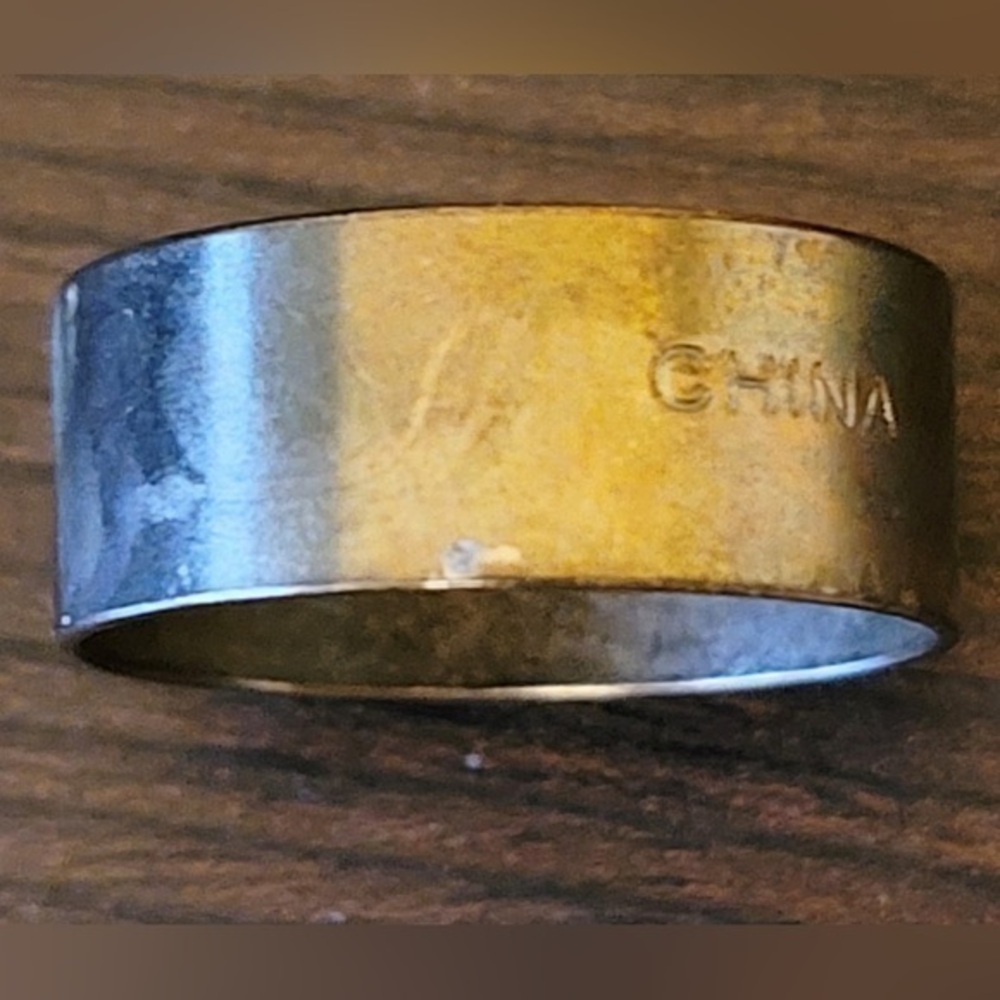 Thick gold tone band size 6-7. Marked china.